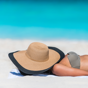 Vrouw slaap slecht op vakantie en is vermoeid aan het zonnen
