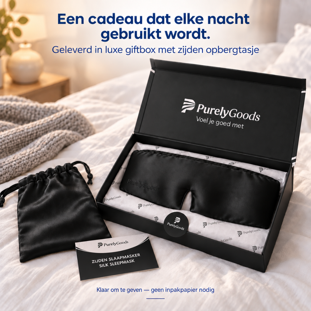 Zwart zijden slaapmasker van PurelyGoods in luxe zwarte giftbox met zijden opbergtasje op een bed