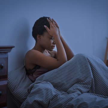 Vrouw met stress in bed voor het slapengaan