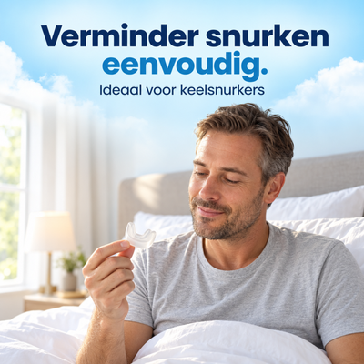 Man zit op bed en houdt de transparante anti-snurkbeugel Comfort in zijn hand.