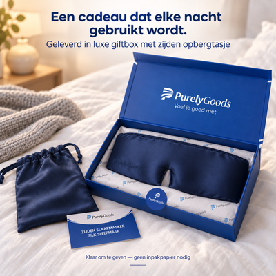 Marineblauw zijden slaapmasker van PurelyGoods in luxe blauwe giftbox met zijden opbergtasje op een bed